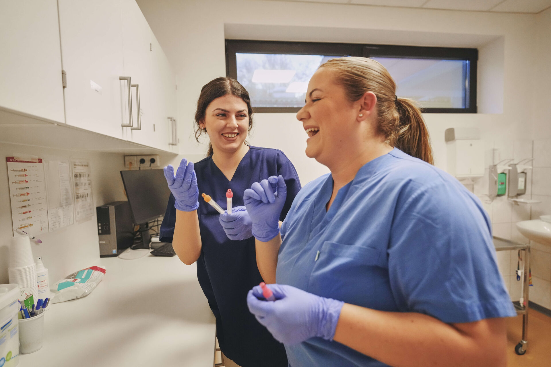 Das Bild zeigt zwei Medizinische Fachangestellte bei der Blutauswertung im Labor.